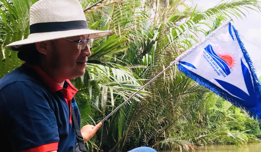 Hướng dẫn viên Miệt Vườn Daily cầm cờ dẫn đoàn tại rừng dừa - Đồng hành tận tâm